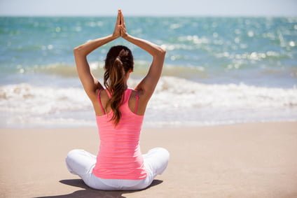 Meditierende Frau am Strand